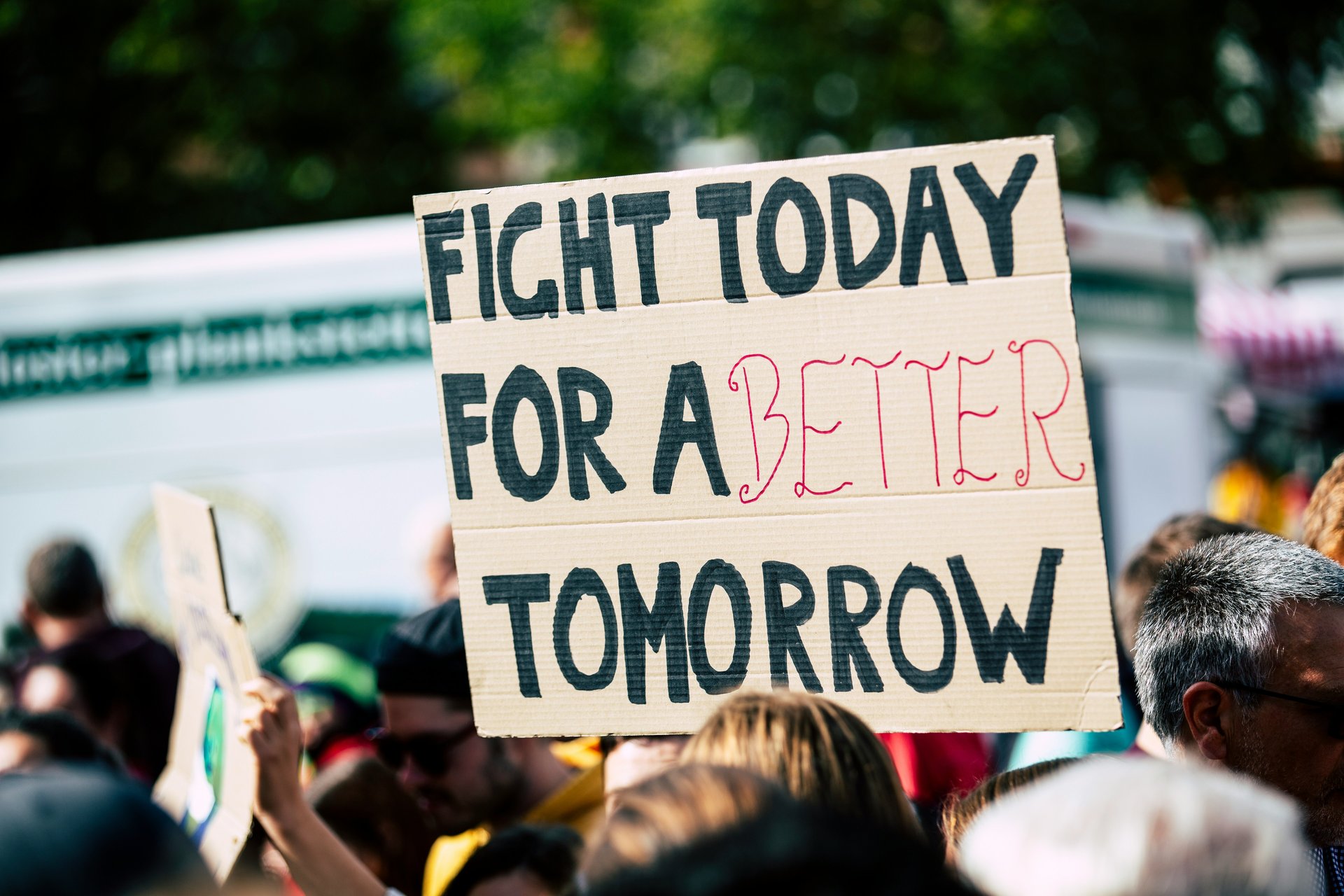 Person holding a sign about fighting for a better tomorrow
