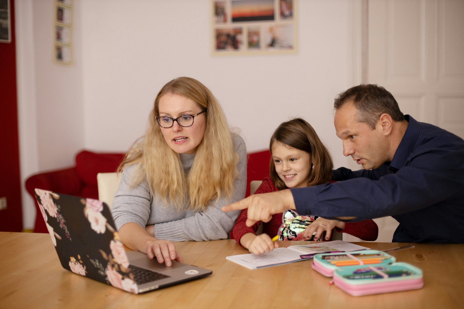 Parents helping a child at a laptop