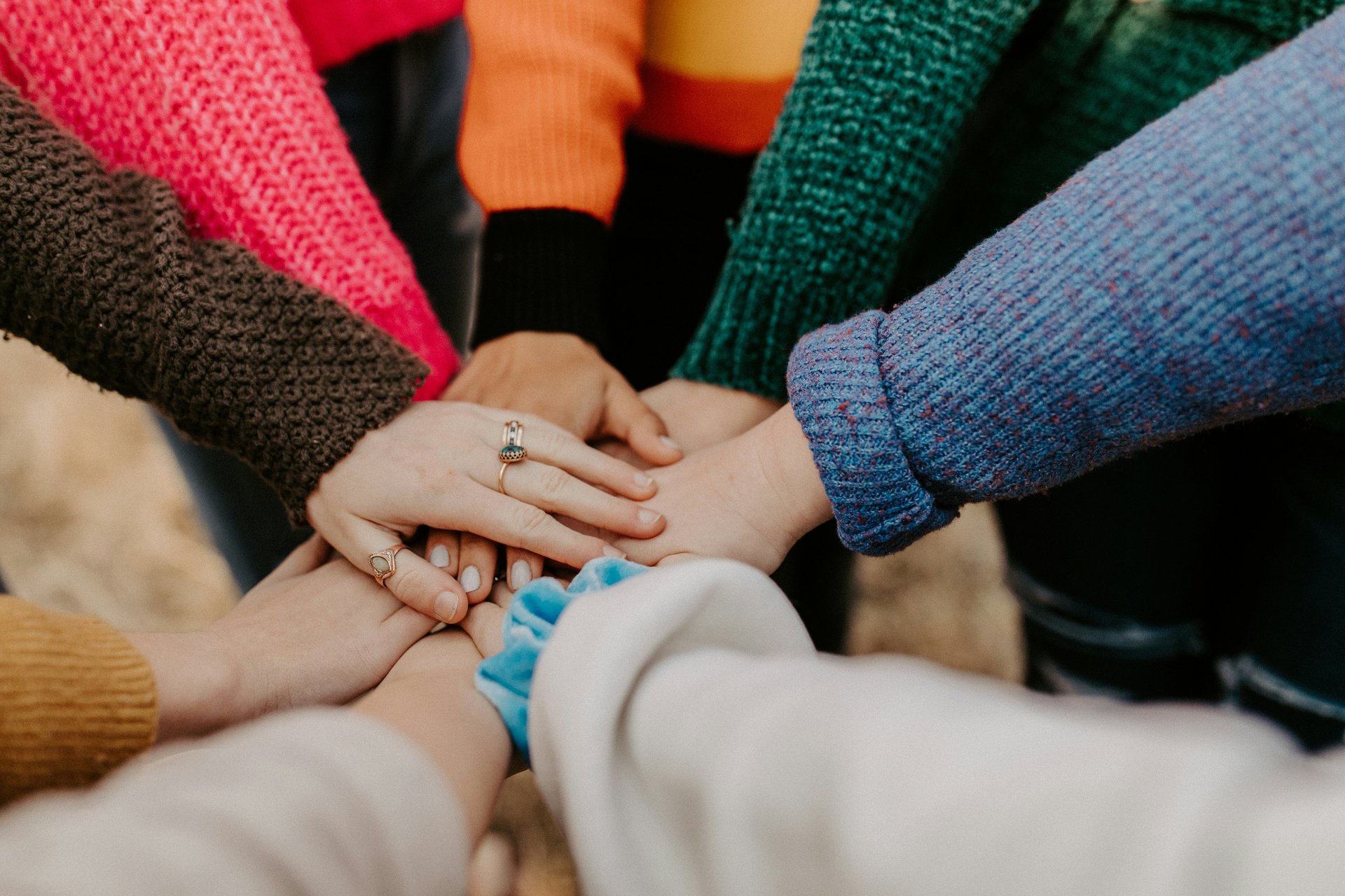 People joining hands in a circle, representing coalition building